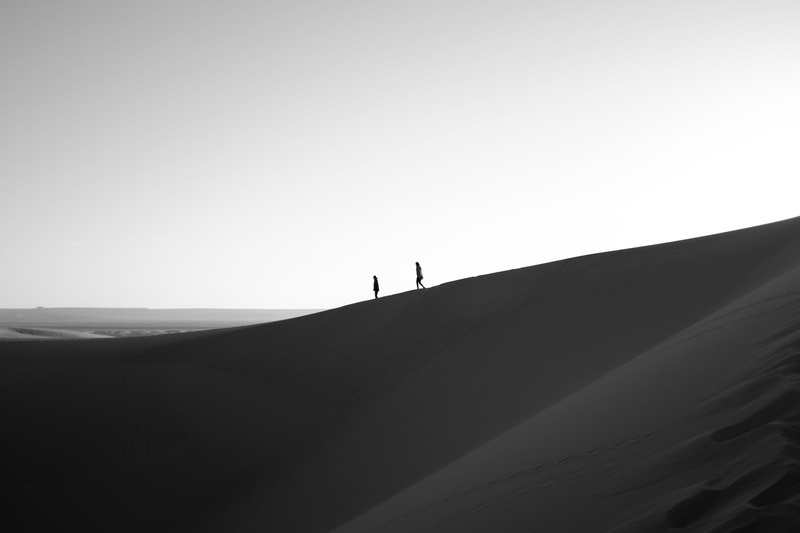 sky, leisure activity, black and white, people, lifestyles, solitude, only men, desert, 2K, hill, outdoors, standing, one person, copy space, beauty in nature
