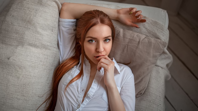 face, looking at viewer, portrait, painted nails, redhead, 1080P, women, couch, white shirt, top view, long hair, finger on lips