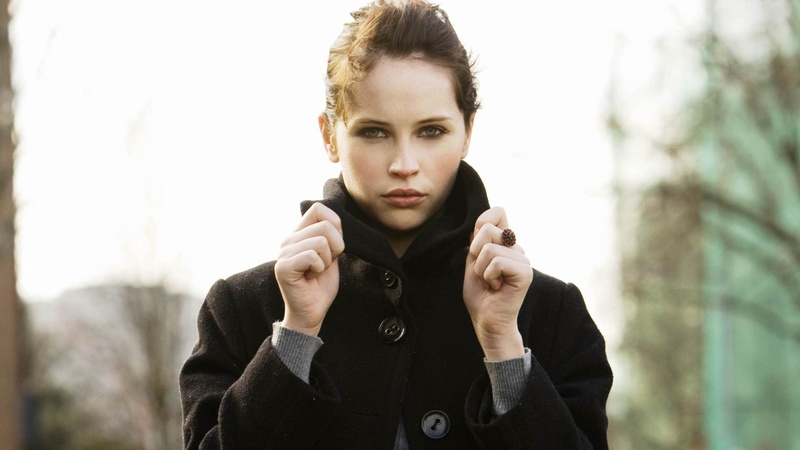 actress, looking at camera, green eyes, hairstyle, women, real people, one person, black coat, warm clothing, Felicity Jones, outdoors, contemplation, focus on foreground