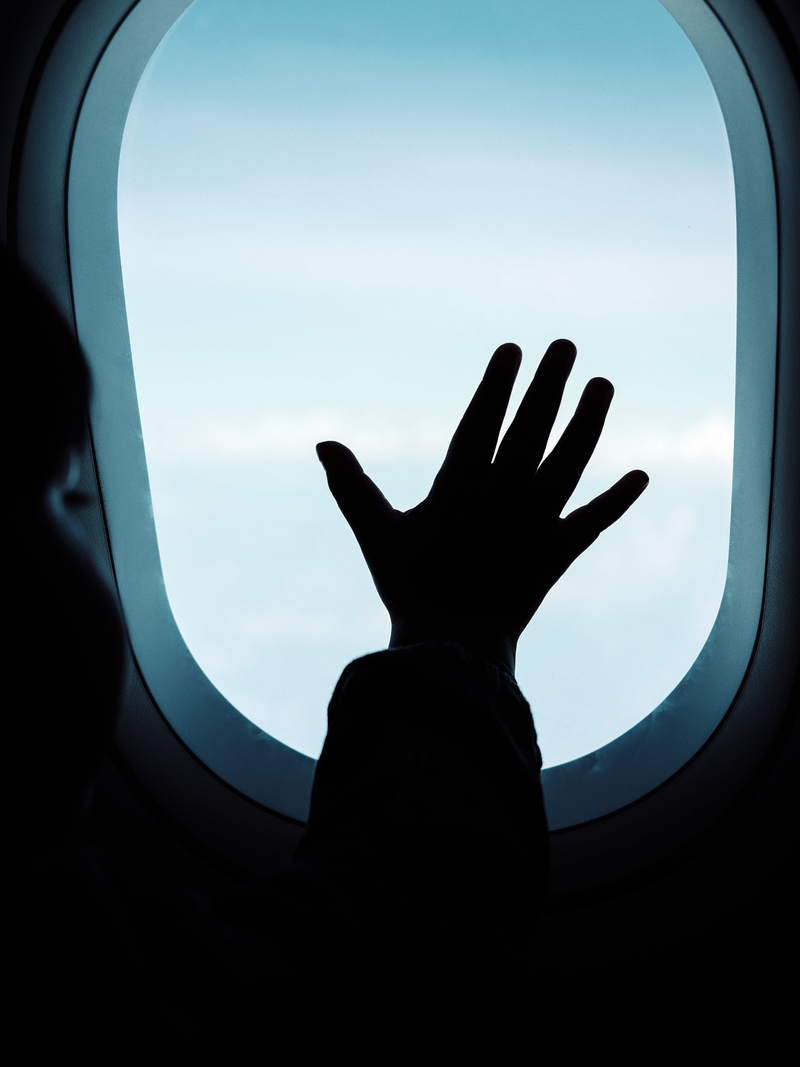 sky, body part, tire, nature, mode of transportation, aircraft, light, finger, airliner, mirror, airplane, window, unrecognizable person, shutter, silhouette