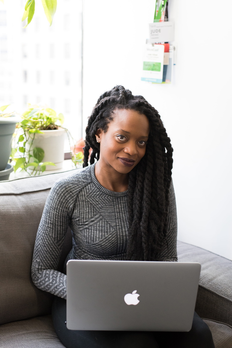 seat, dreadlocks, looking at camera, person, lap, digital nomad, front view, laptop, lady, woman, furniture, communication, sweater, remote work, model