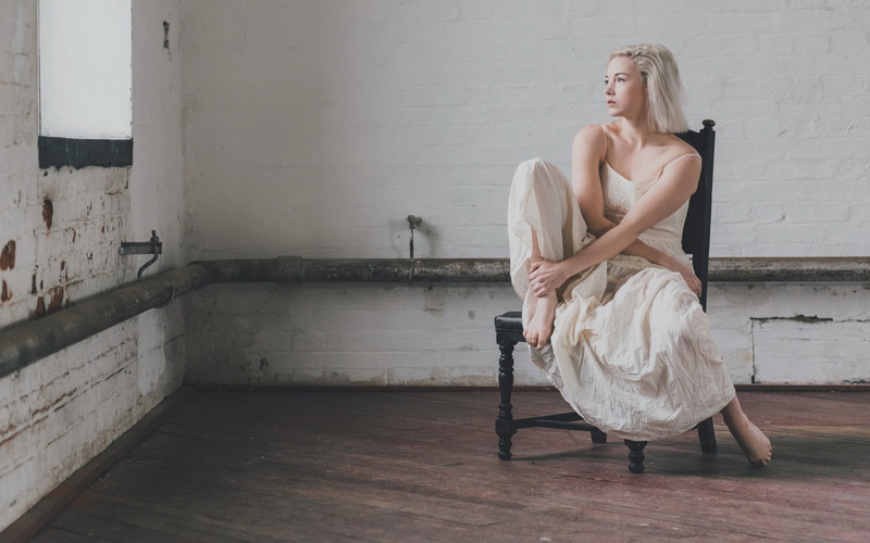 hairstyle, adult, indoors, young adult, fashion, young women, chair, hair, room, women, blonde, blond hair, barefoot, sitting, wall - building feature
