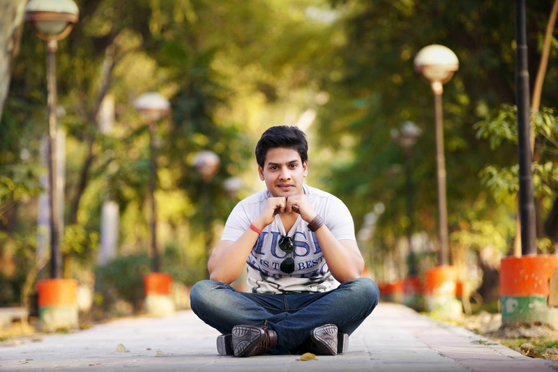 5K, portrait, young adult, front view, hand on knee, sunny, sitting, tree, one person, real people, outdoor, indian, full length, focus on foreground