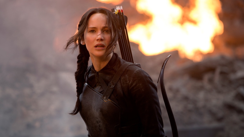 focus on foreground, adult, leather, beautiful woman, women, looking at camera, standing, jennifer lawrence, bow, one person, front view, fire, the hunger games: mockingjay part 1