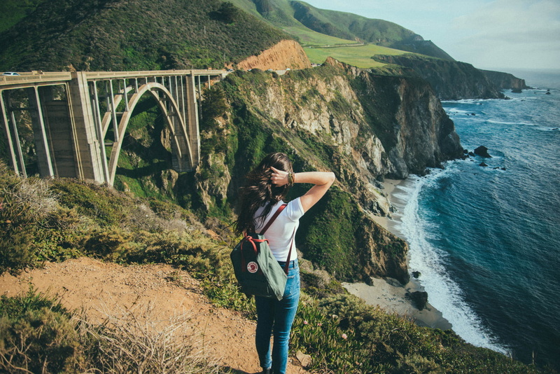 looking into the distance, women, connection, rock, sea, standing, leisure activity, backpacks, full length, beauty in nature, one person, adult, landscape