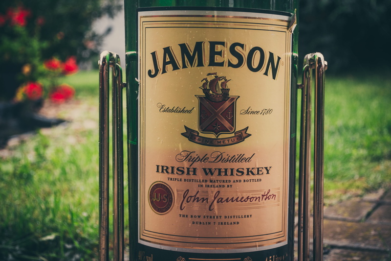jameson, information sign, non-western script, outdoors, red, green, established, 4K, guidance, focus on foreground, text, ground, photo, sign, wine bottle