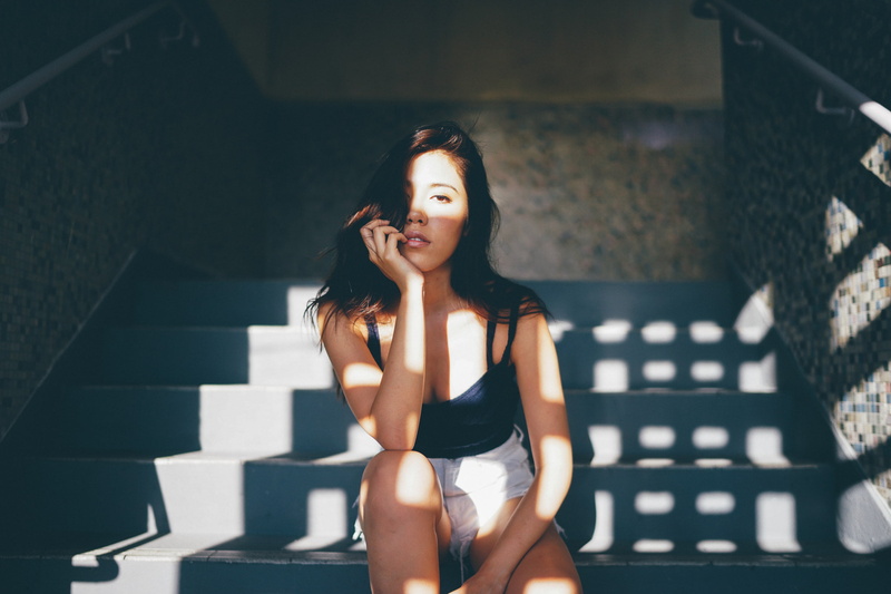 hot pants, black tops, brown eyes, hand on face, indoors, 1080P, looking at viewer, contemplation, adult, hairstyle, lifestyles, leisure activity, sitting