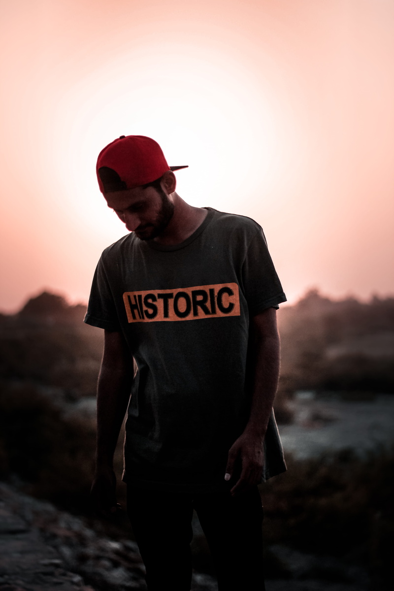looking down, boy, person, young, model, dark, mid adult, leisure activity, leisure, standing, hat, text, light, red, gray, 5K, focus on foreground, man