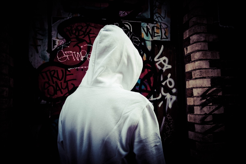 indoors, built structure, one person, architecture, lifestyles, street art, casual clothing, dark, real people, street, clothing, rear view, graffiti, headshot