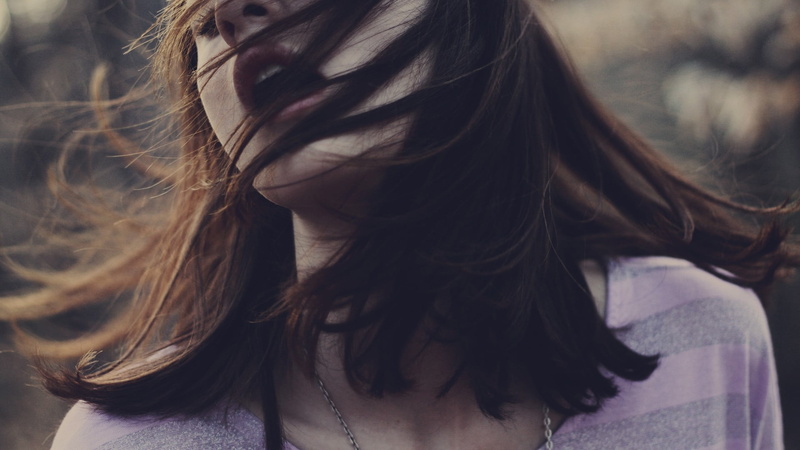young women, brunette, women, hair in face, casual clothing, lifestyles, long hair, real people, one person, tousled hair, human face, human hair, focus on foreground