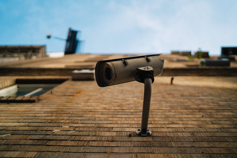 no people, brown, camera, city, gray, brick, home video camera, binoculars, focus on foreground, 8K, outdoors, built structure, security camera, window
