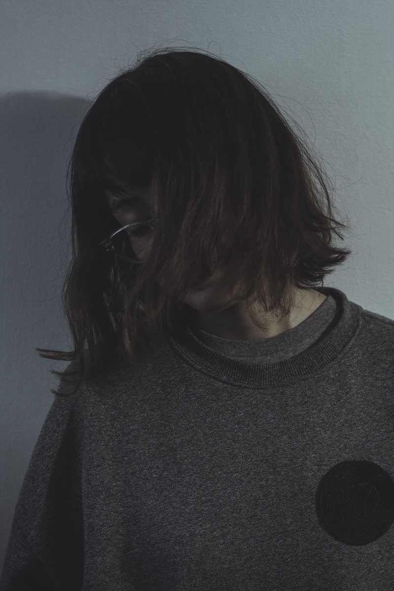 wall, teenager, contemplation, adult, human hair, white, one person, front view, gray, wall - building feature, sweater, lifestyles, leisure activity, people