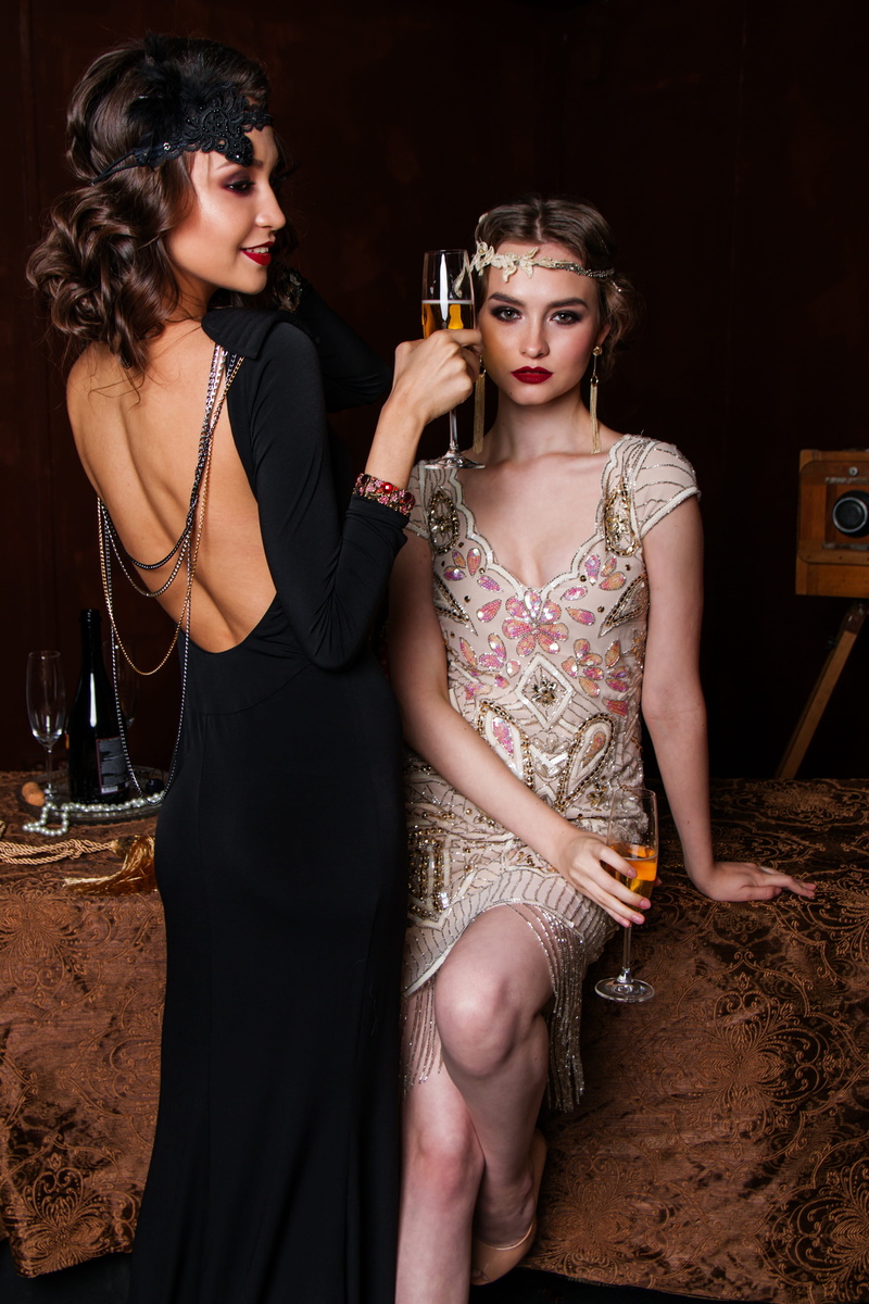 camera, glass, wearing, people, champagne, studio, couple - relationship, two, sitting, beautiful, formalwear, woman, backless, makeup, wine, standing