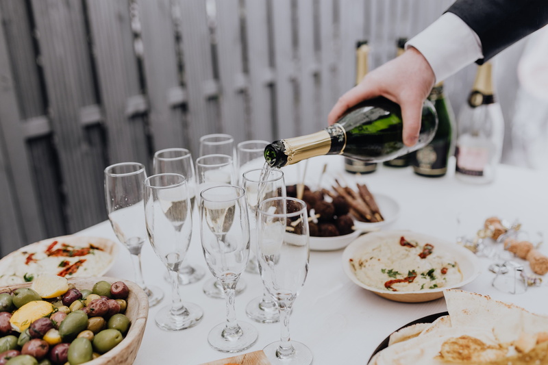 real people, table, pouring, wine, drinking, white, glasses, hand, alcohol, one person, indoors, food, refreshment, white wine, food and drink, party, plate