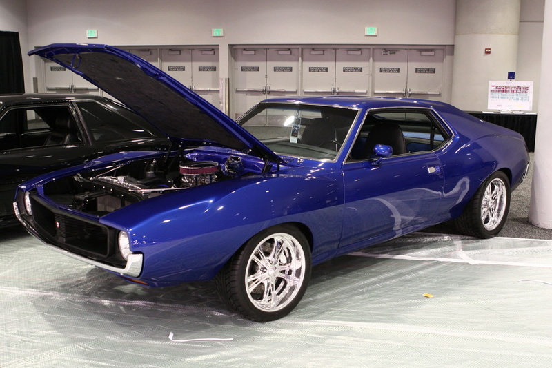 side view, stationary, motor vehicle, wheel, luxury, land vehicle, shiny, 720P, auto repair shop, architecture, indoors, car, amc amx, vintage car, transportation