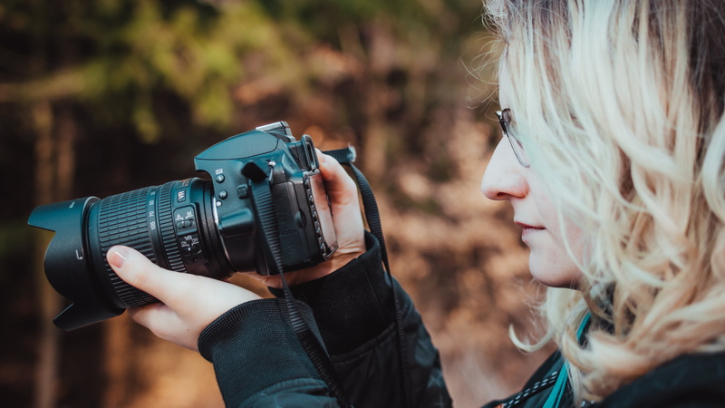photographic equipment, digital camera, platinum blonde, lifestyles, holding, modern, activity, blonde, photographer, hairstyle, occupation, focus on foreground