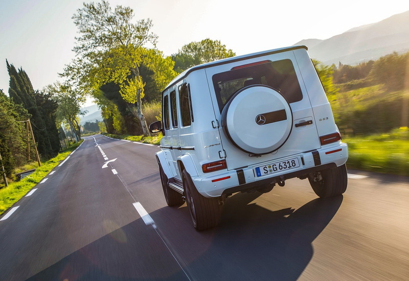 car, symbol, mode of transportation, g63, land vehicle, country road, tree, no people, outdoors, sign, sunlight, road, speed, mercedes-benz, motor vehicle
