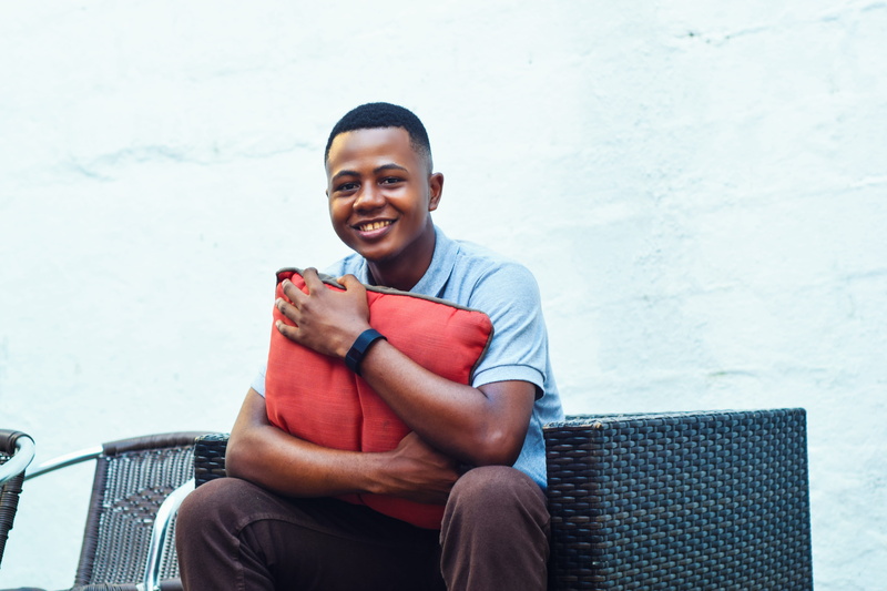 cushion, emotion, red, gray, sofa, holding, one person, casual clothing, lifestyles, white, pillow, shirt, near, young women, seat, man, looking at camera