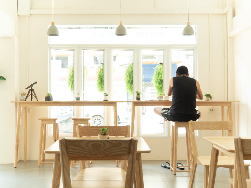 inside, hairstyle, contemporary, vases, seat, chair, tables, sitting, adult, table, modern, beside, man, real people, glass windows, sofa, one person, daytime