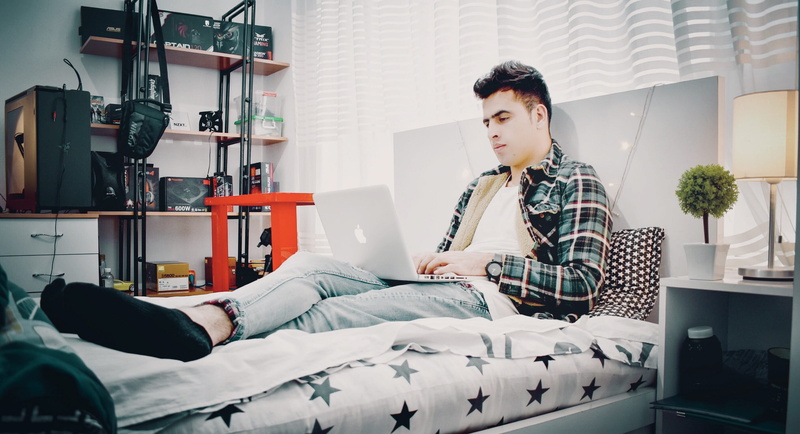 shirt, green, laptop, lamp, using, sitting, macbook, sports, person, business, 2K, man, young men, furniture, indoors, one person, bedroom, wear, bed