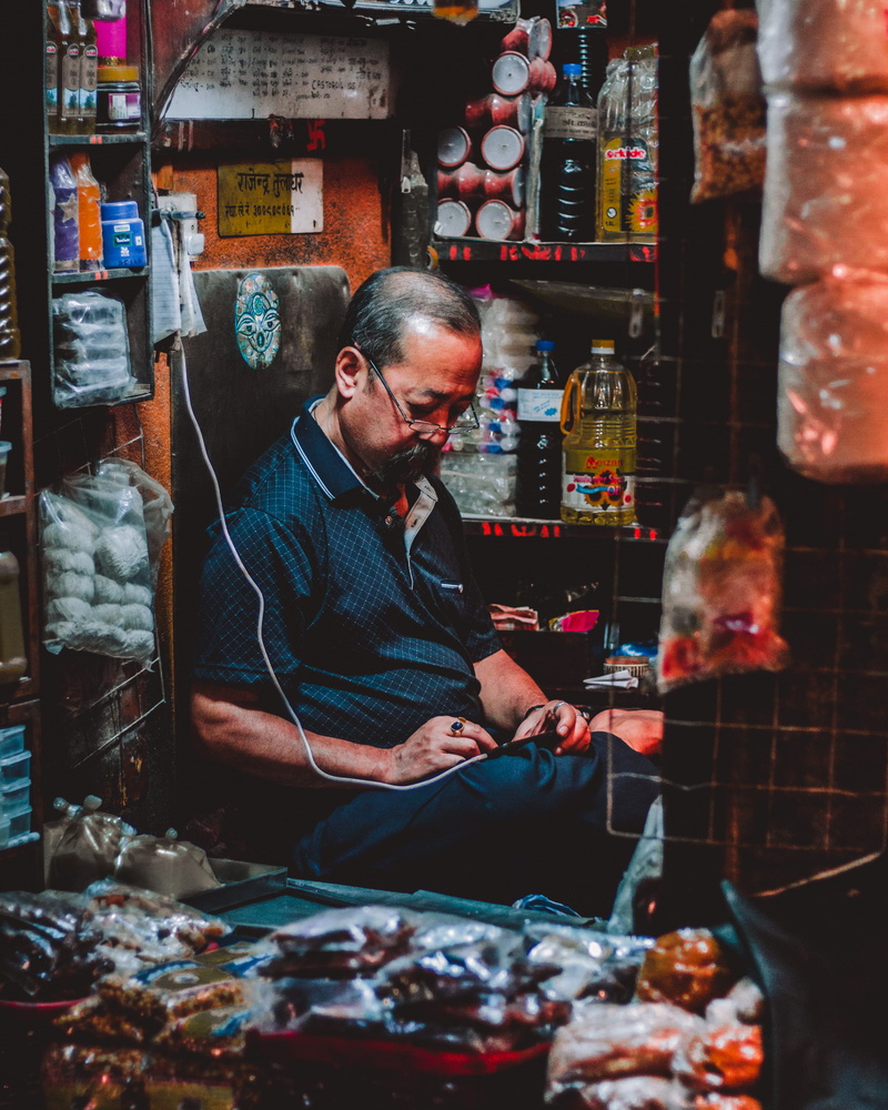 moustache, people, phone, mid adult, retail, person, human, food and drink, city, device, retail display, market, one person, shop, shopkeeper, candid