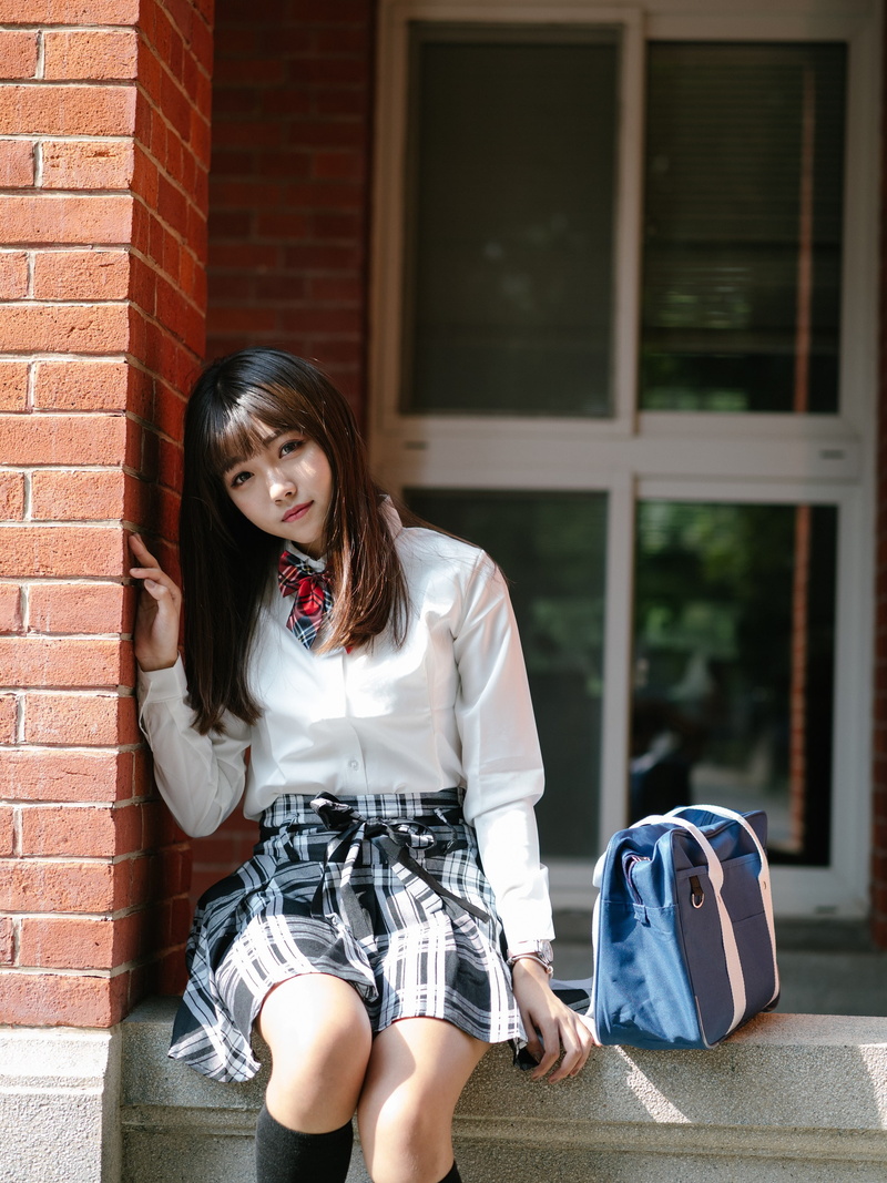 bricks, casual clothing, portrait, outdoors, architecture, skirt, brick wall, sitting, long hair, brunette, young adult, brown hair, shirt, building exterior