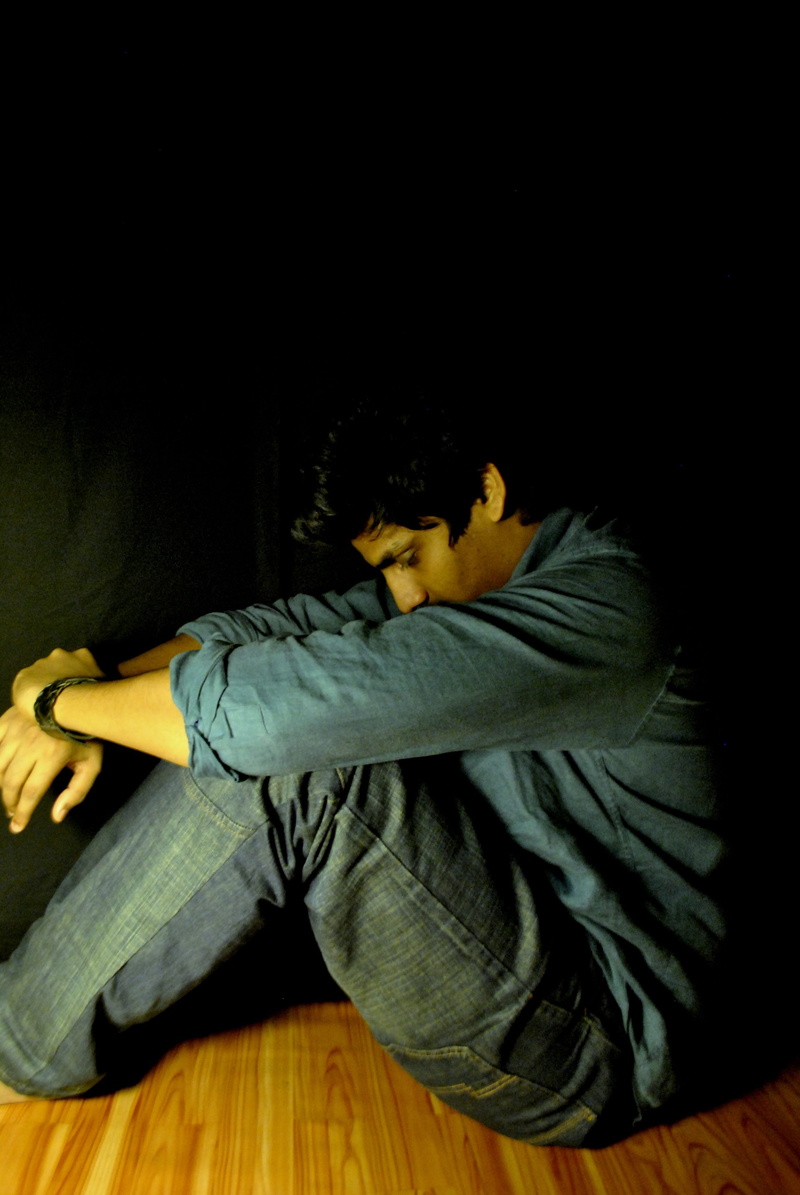 full length, unhappy, indoors, hairstyle, black background, wooden plank, wood, lonely, relaxation, man, flooring, shirt, problem, brown, yellow, emotion