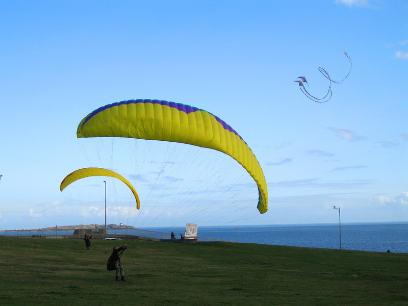 mid-air, flying, glider, sport, wind, one person, day, kite, sky, flyer, land, adventure, real people, outdoors, air, paragliding, lifestyles, water, gliding