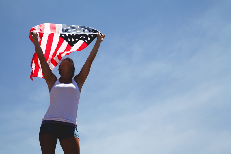 human limb, copy space, human body part, arms raised, blue, sunlight, 5K, sky, standing, lifestyles, flag, american flag, clothing, day, woman, one person