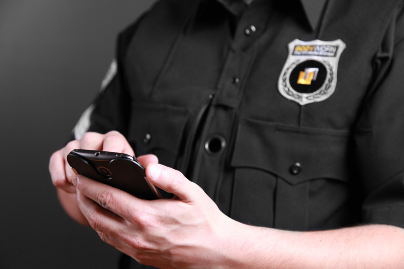 body camera, profession, holding, on-body camera, 5K, midsection, human hand, smartphone, men, guard, one person, mobile phone, person, law enforcement