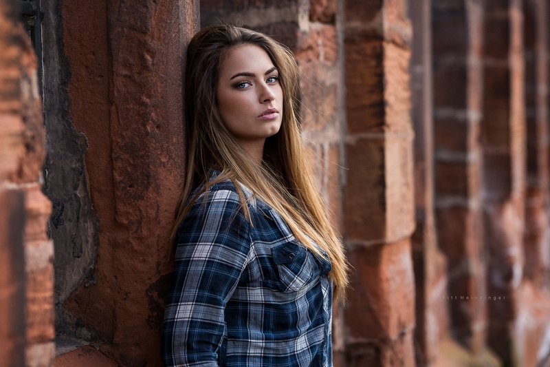 looking at viewer, young women, leaning, contemplation, hairstyle, beautiful woman, casual clothing, brunette, bricks, waist up, women outdoors, portrait