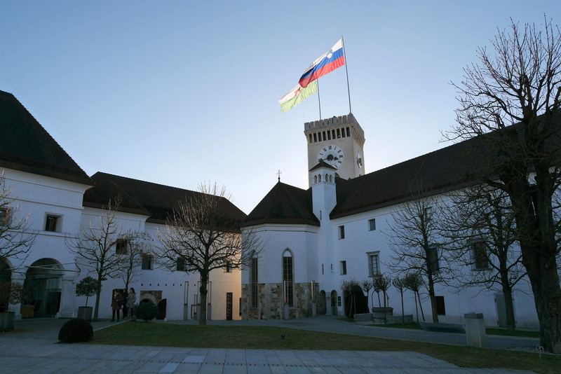 day, religion, castle, outdoors, clear sky, sky, bare tree, plant, slovenia, tree, low angle view, flag, built structure, architecture, nature, building