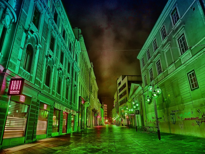 illuminated, concrete, building, street, no people, sky, shops, outdoors, diminishing perspective, sidewalk, stores, green color, nature, city