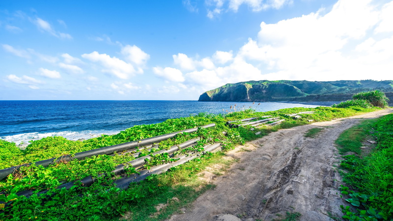 road, green color, nature lover, water, dirt road, path, horizon over water, beauty in nature, tranquility, idyllic, cloud - sky, horizon, nature, batanes