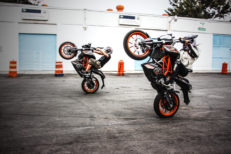 driver, road, full length, building exterior, city, cyclist, two, helmet, transportation, teenager, stunt, bike, action, motorcycle, men, day, bikes, black