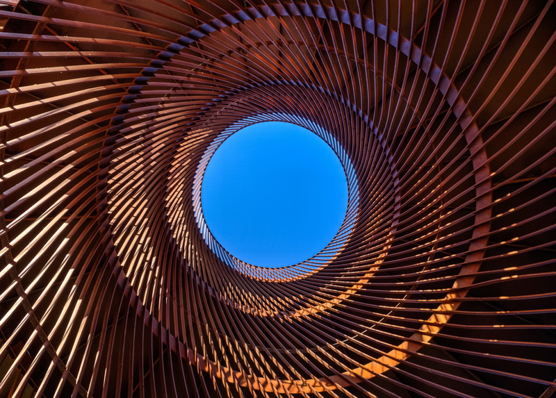 concentric, metal, clear sky, art, engineering structure, spiral, red, day, sky, cylindrical, orange, geometric, circle, abstract, architecture, light and shadow