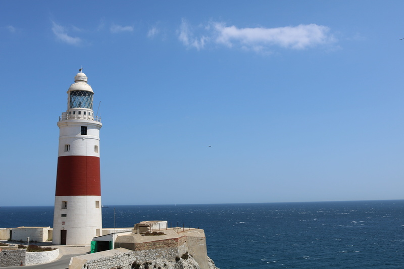 red, guidance, cylindrical, tower, safety, horizon over water, no people, lighthouse, mediterranean, security, direction, building exterior, water, punta europa