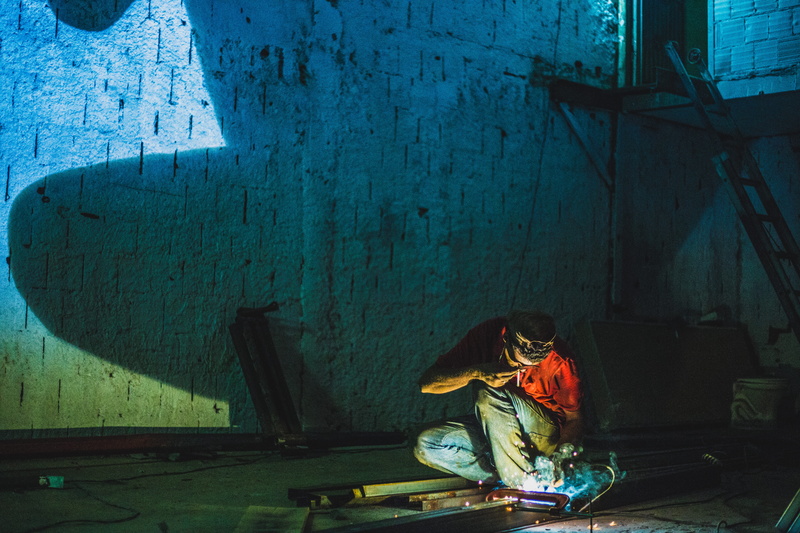 neck, workshop, 5K, one person, shirt, smoke, locksmith, nigth, shadow, crew, sitting, casual clothing, musician, lifestyles, social issues, wall - building feature