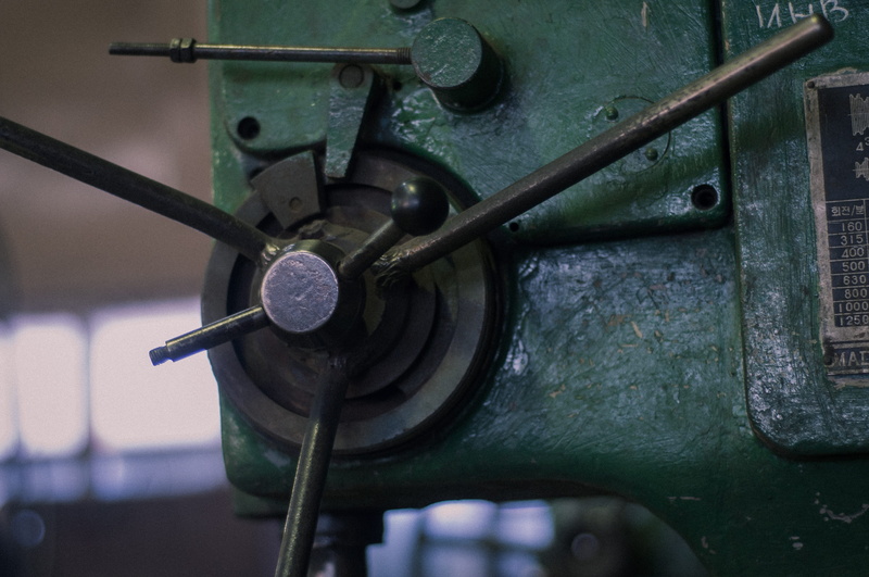 brake, factory, green color, day, propeller, rotor, gear, close-up, mode of transportation, machine, drive shaft, machinery, machine part, screw, weaponry