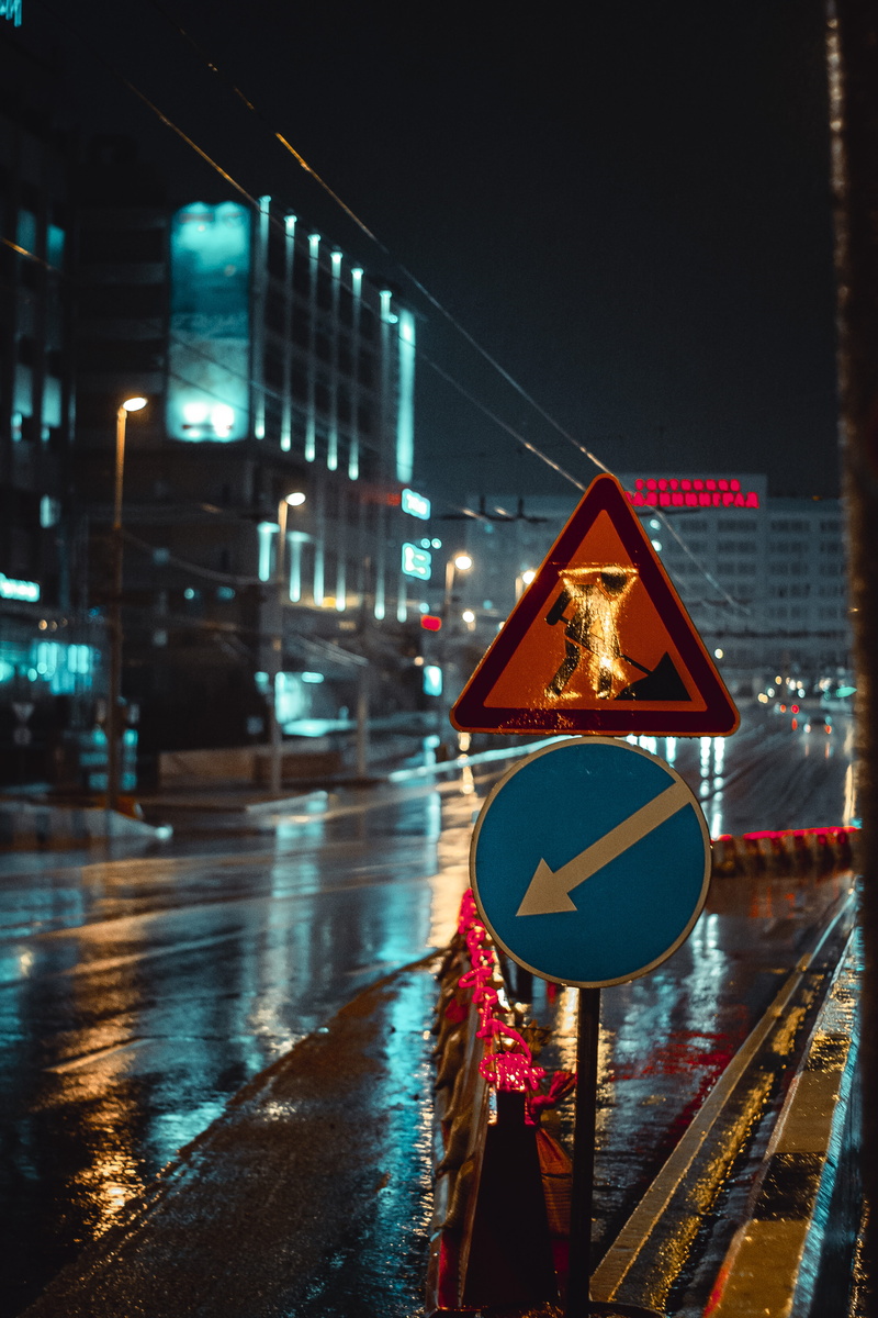 blue, time lapse, wet, traffic sign, urban, lights, sign, night, built structure, blur, transportation, modern, building exterior, focus on foreground