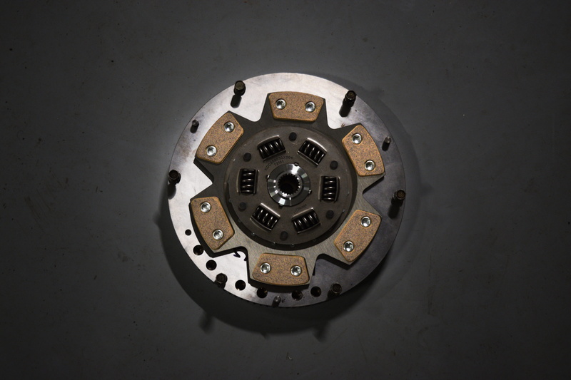 clutch, black background, technology, still life, disk, 5K, studio shot, no people, repair, engine, gray, machine, car parts, metal, directly above, communication
