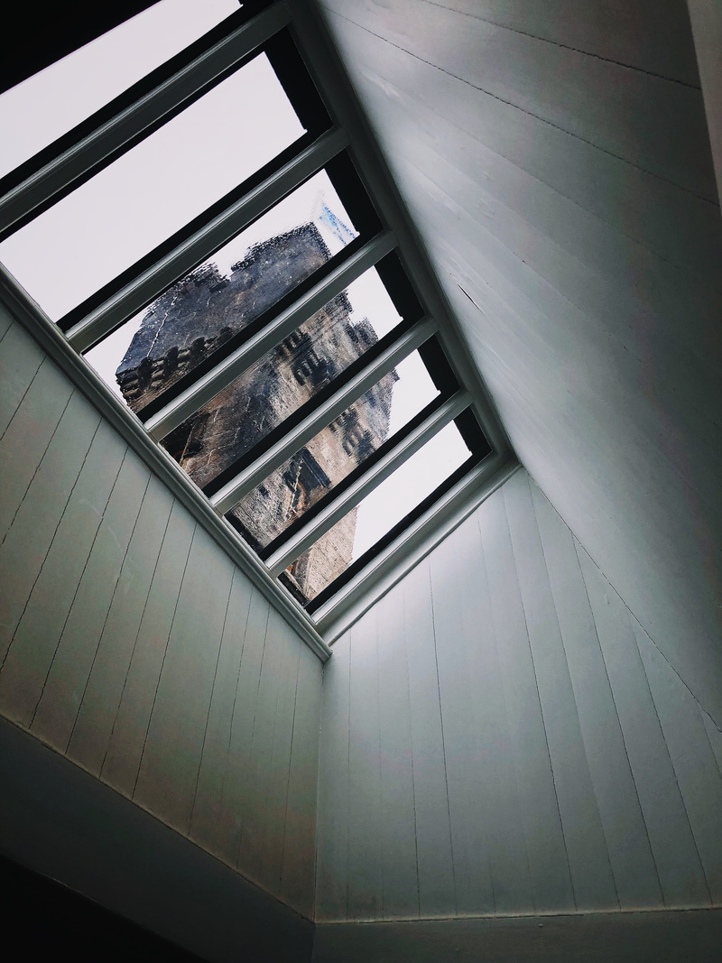 looking out, building, pattern, wall - building feature, steps and staircases, juxtapose, framed, flag, day, railing, window, skylight, transparent, roof