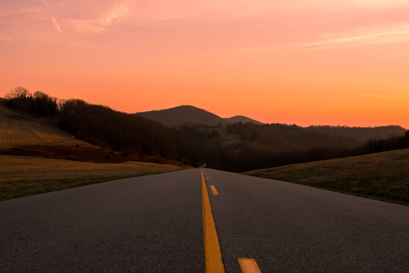 highway, landscape, outdoors, road, no people, mountain, asphalt, nature, tarmac, road marking, sign, direction, double yellow line, dividing line, dusk