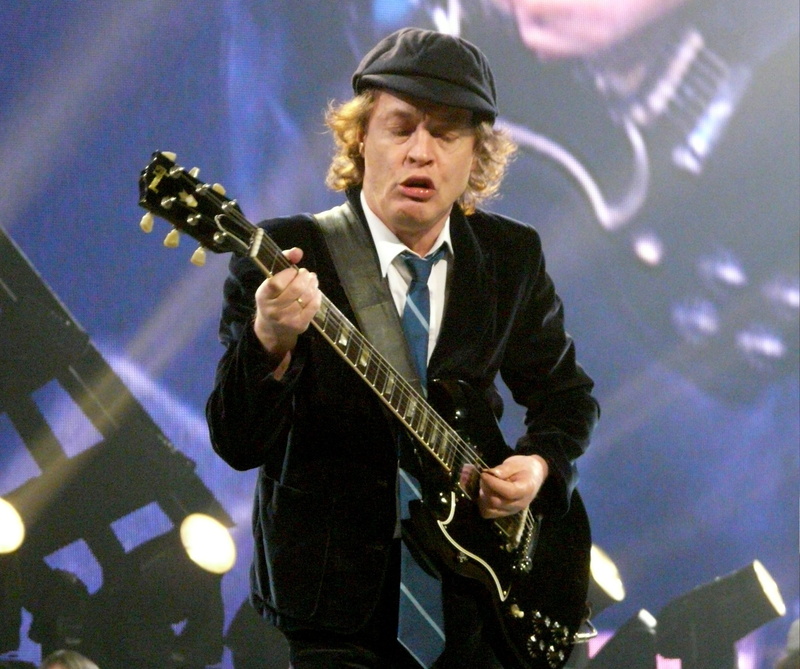 string instrument, artist, performance, men, electric guitar, indoors, plucking an instrument, musical instrument, one person, stage, waist up, Angus Young