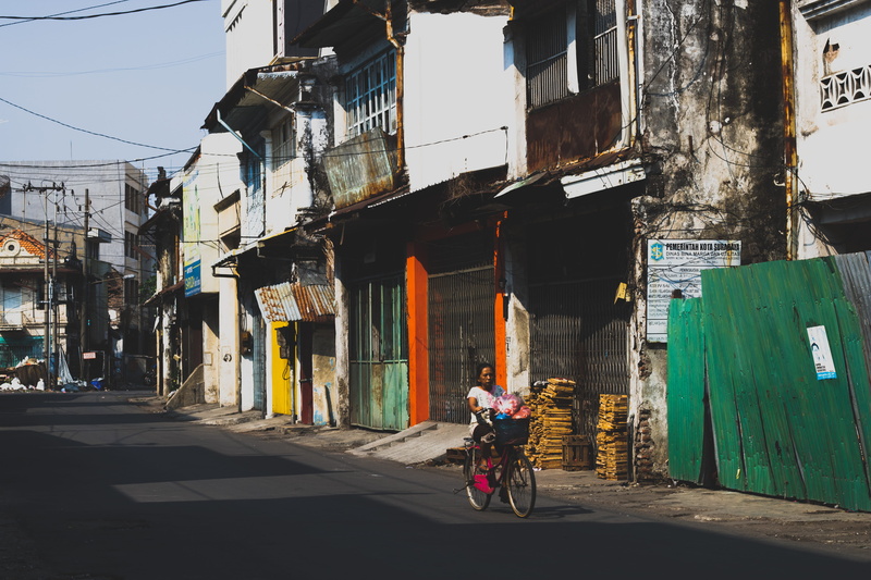 day, building exterior, bicycle, vehicle, person, woman, 5K, land vehicle, riding, asphalt, human, path, sports, intersection, lifestyles, one person