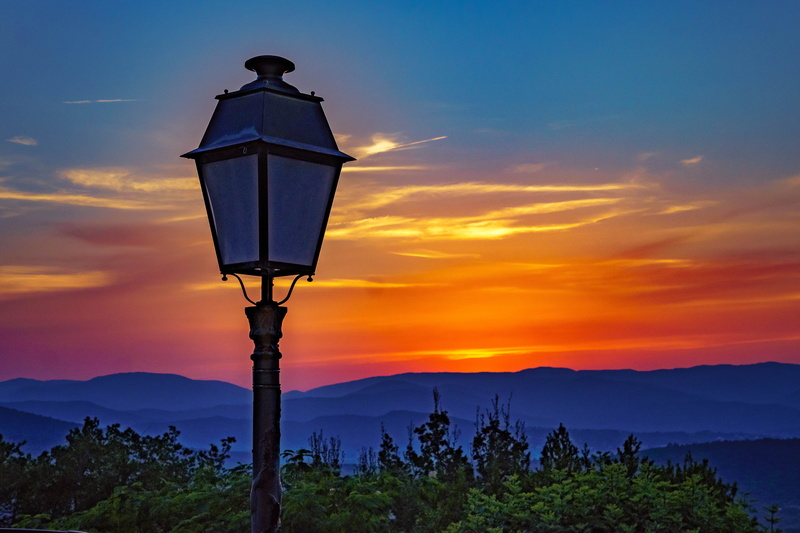 street light, lighting equipment, street, environment, sunset, twilight, sky, clouds, evening sky, mountain peak, nature, tree, beauty in nature, scenic