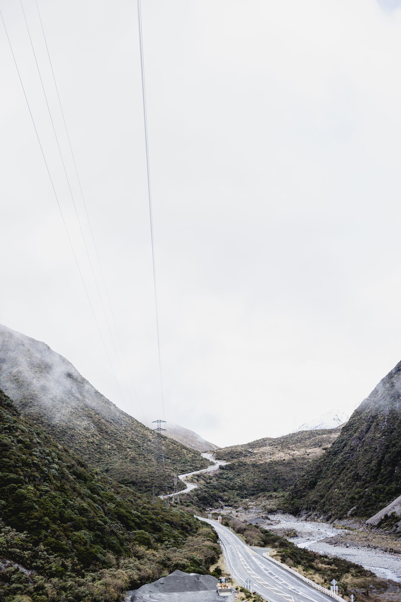 power supply, no people, canyon, connection, power lines, sky, tranquility, non-urban scene, environment, adventure, dirt road, vehicle, electricity, slope