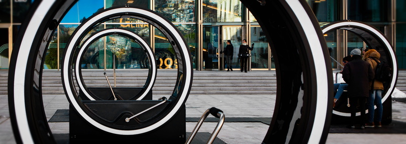 reflection, real people, men, day, window, wheel, building exterior, museum, city, concentric, art, lifestyles, railing, rear view, transportation, mode of transportation