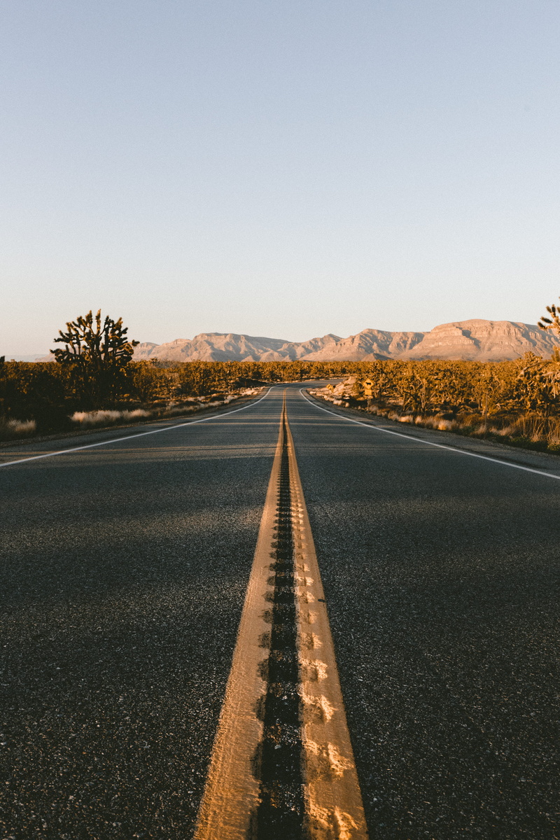 empty road, diminishing perspective, mountain, nature, sign, shadow, near, sunset, texture, road, view, driving, low, yellow line, transportation, sky