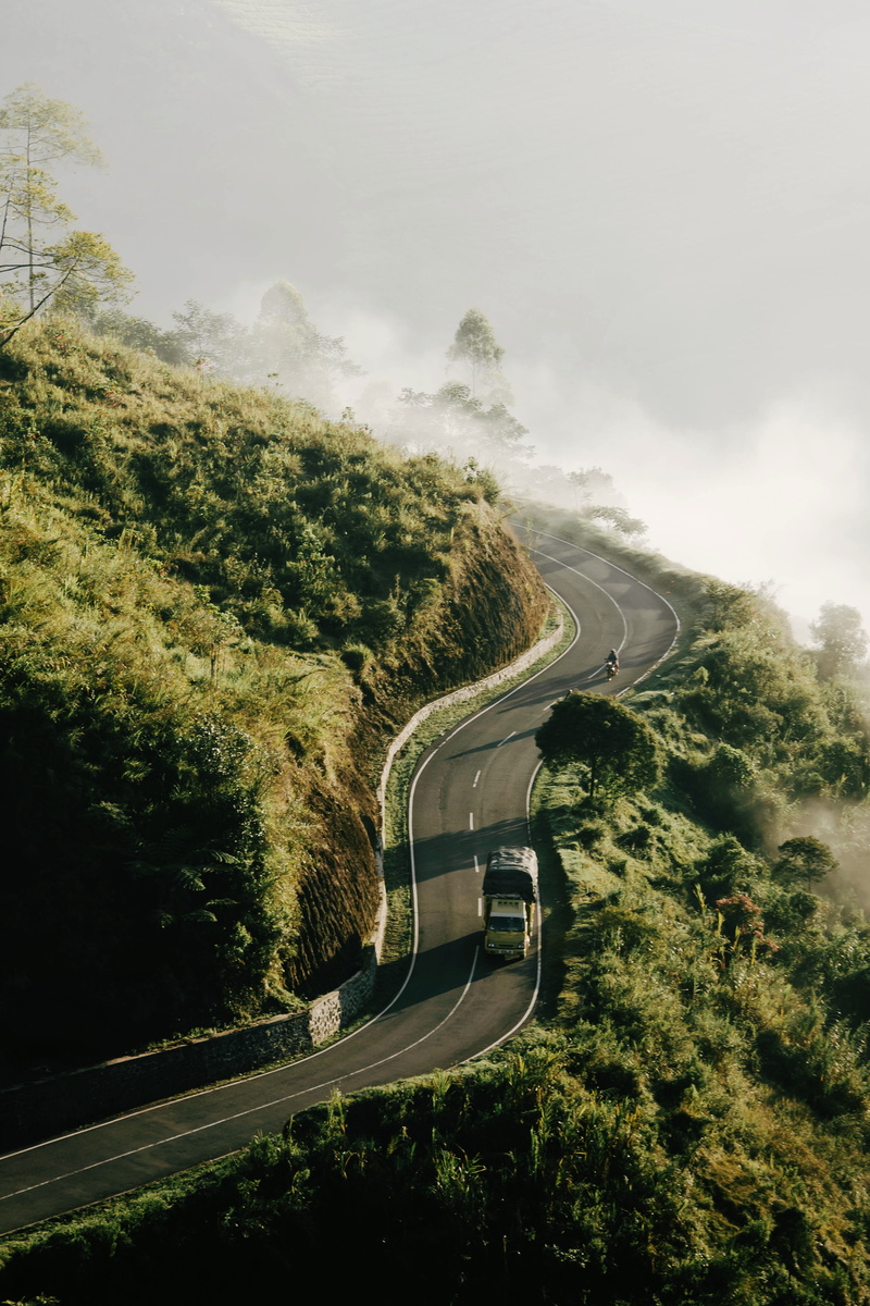 ridge, indonesia, environment, sunlight, fog, mountain road, haze, curve, mode of transportation, gravel, forest, car, road, scenery, scenics - nature